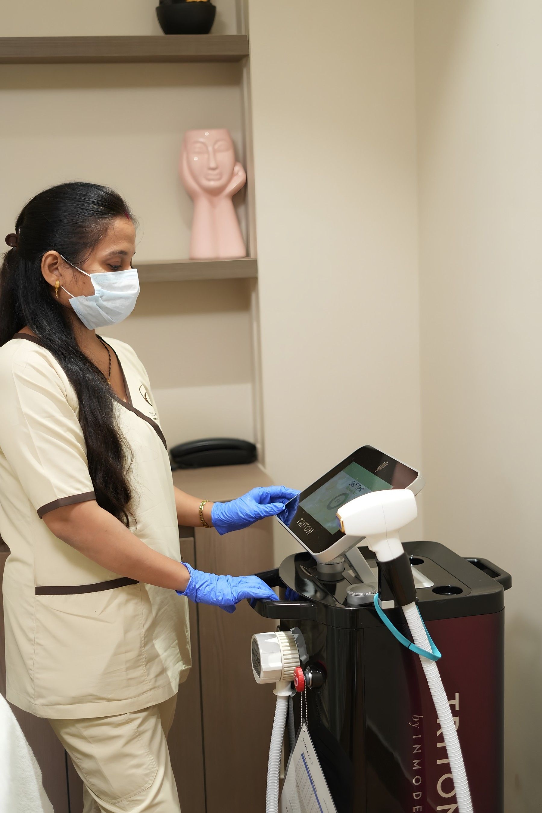 Therapist setting up the laser hair reduction system in a treatment room at The Asense