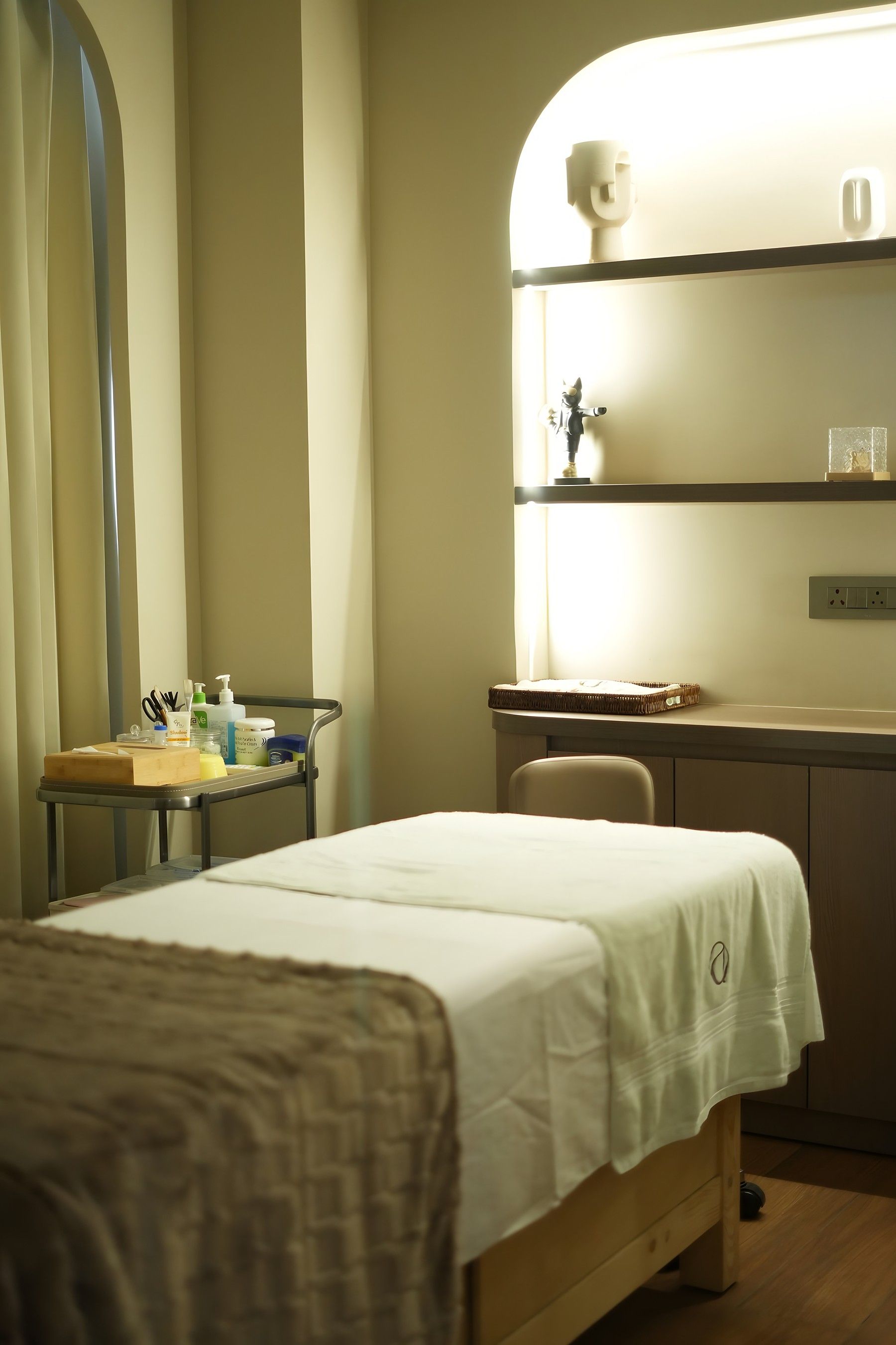A private treatment suite at The Asense, Punjabi Bagh, with a monogrammed towel and softly lit shelves